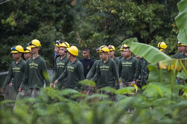 Thai soldiers walk out from the Tham Luang cave area