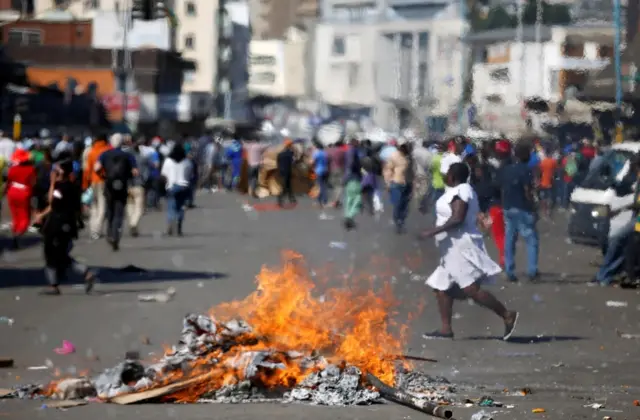 Locals run as supporters of the opposition Movement for Democratic Change party (MDC) of Nelson Chamisa burn barricades in Harare, Zimbabwe, August 1, 2018