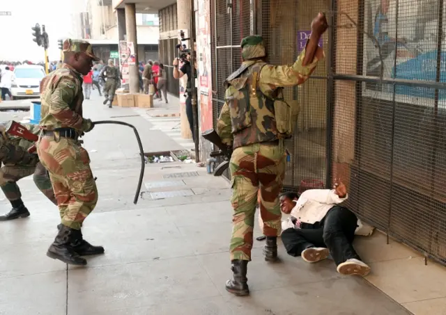 Soldiers beat a supporter of the opposition Movement for Democratic Change party of Nelson Chamisa outside the party"s headquarters as they await the results of the general elections in Harare, Zimbabwe, August 1, 2018.