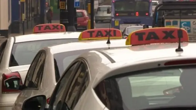 Taxis with taxi signs on their roof