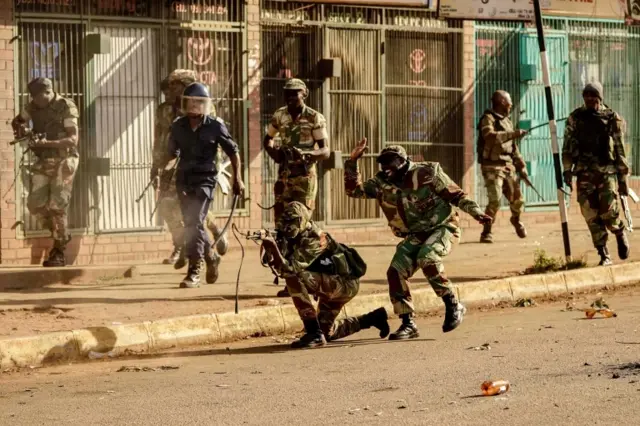 A soldier fires shots towards demonstrators, on August 1 2018, as protests erupted over alleged fraud in the country"s election