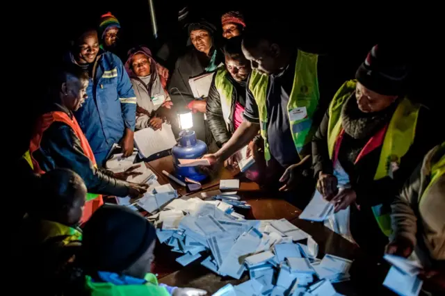 Observers check the tally of votes at a polling station for the general election in the suburb of Mbare of Zimbabwe's capital Harare on July 30, 2018