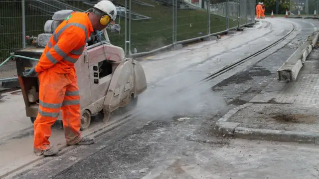 A man in orange replaces the rail on the network