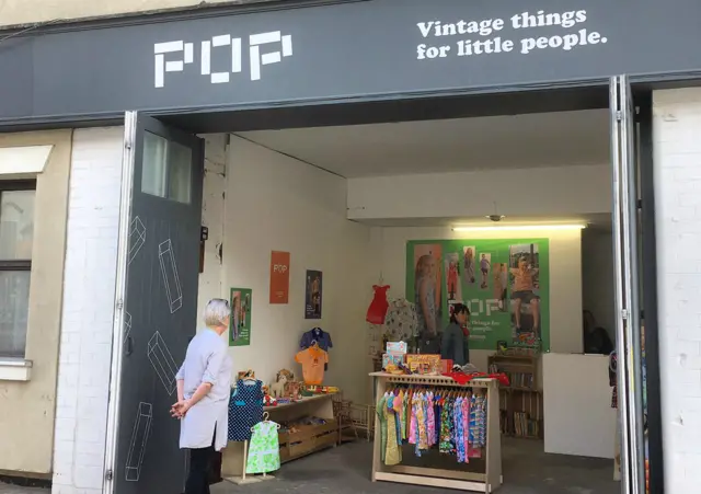 A woman peers into an open shop front