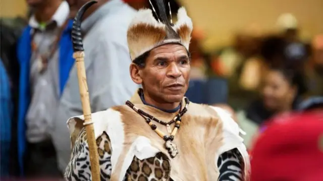 A man in Khoi San regalia in Cape Town on Friday attends a public hearing about the South African government's plan to expropriate white-owned land without compensation.