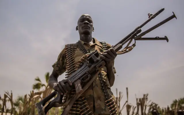 A rebel soldier poses with his gun in Touch Riak, Leer county, on March 7, 2018, where famine has been declared since February 2017.