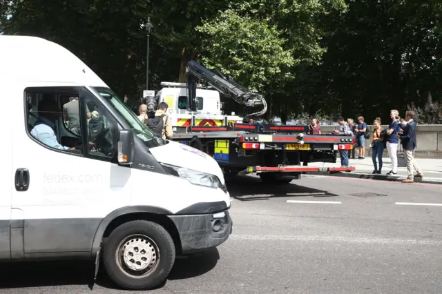 A low-loader arrives at the scene near Parliament