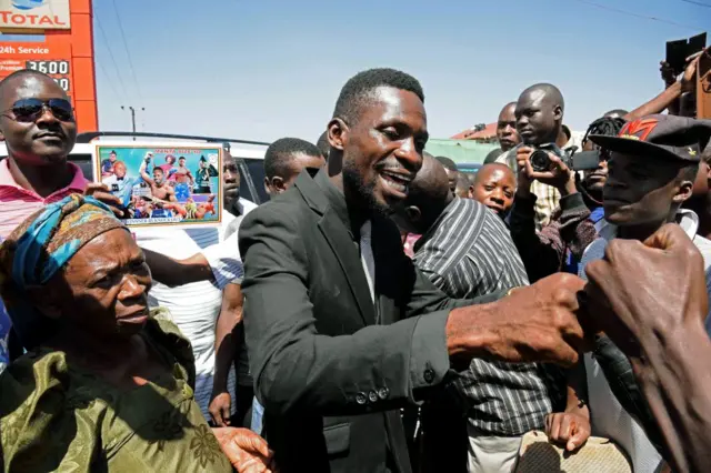 Robert Ssentamu Kyagulanyi commonly known as 'Bobi wine' (C) greets his supporters in a suburb of Kampala on June 30, 2017