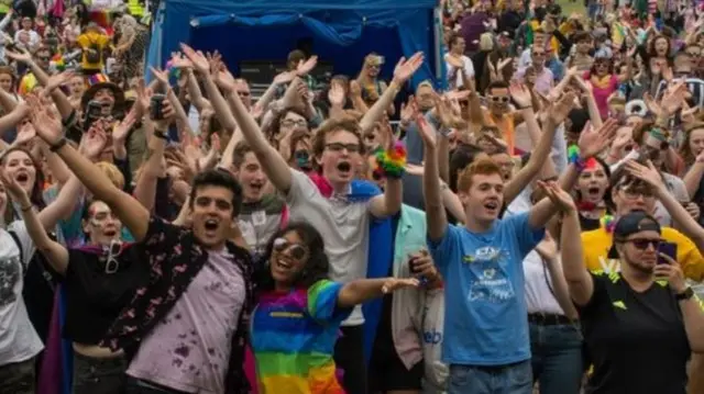 People holding their arms up at an event