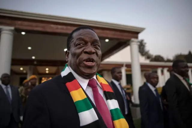 Emmerson Mnangagwa steps onto the lawn to pose for photographs after attending a press conference on August 3, 2018 in Harare