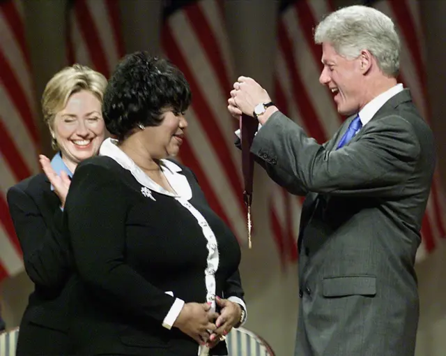 US President Bill Clinton along with First Lady Hillary Rodham Clinton award singer Aretha Franklin with the 1999 National Medal of Arts and Humanities Award 29 September, 1999