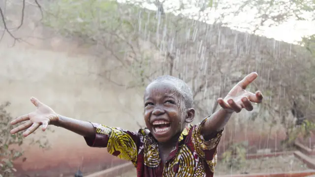 A joyous child out in the rain