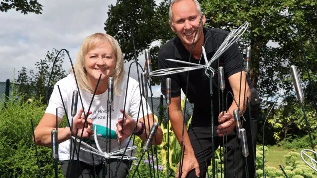 Pictured with the dragonfly and bulrush metal work is Lindsey Richards, of the hospice (left), together with Paul Newbury of Novus.