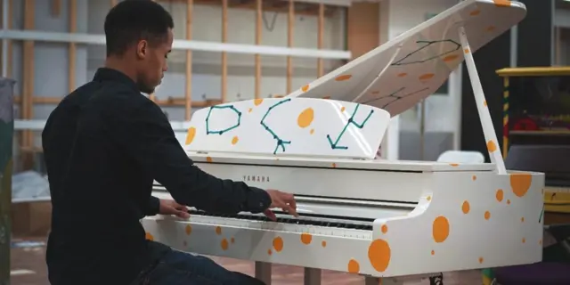 A man playing one of the pianos