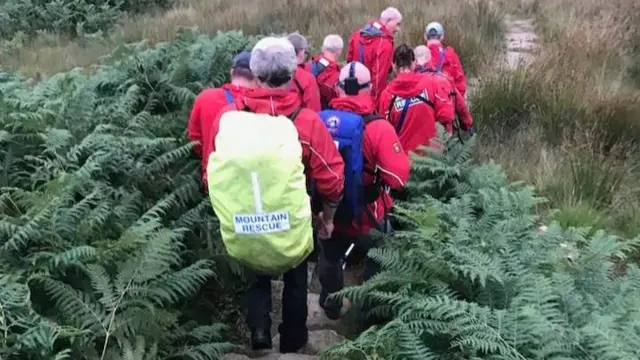 Team carry man on stretcher