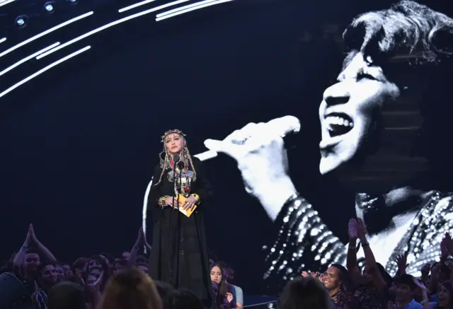 Madonna in front of Aretha Franklin image