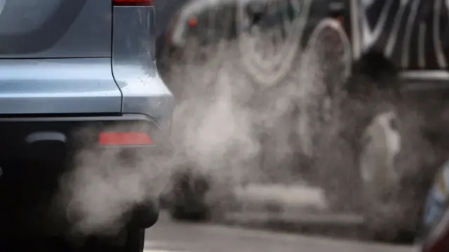 A car with pollution coming out of the exhaust