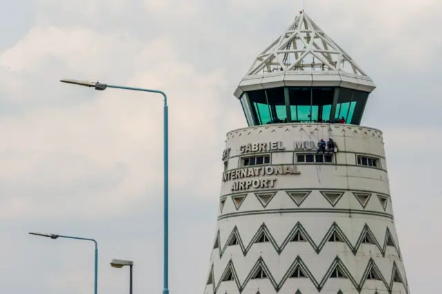 Workers put finishing touches on the new sign at Zimbabwe's main international airport in Harare renamed after Zimbabwean President Robert Gabriel Mugabe on 9 November 2017 - Harare, Zimbabwe