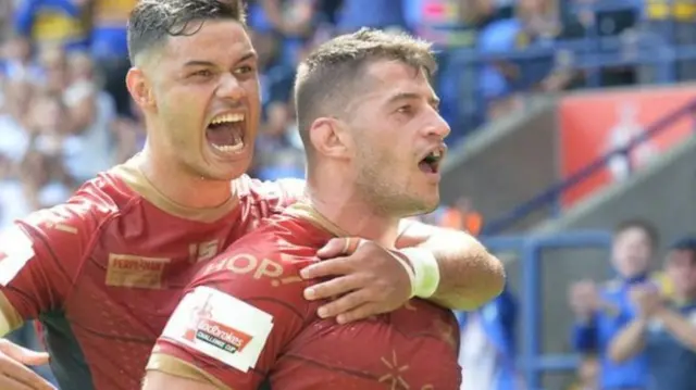 Catalans Dragons players celebrate a try