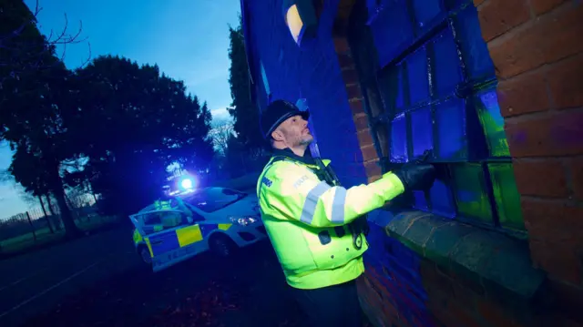 Police officer checking windows