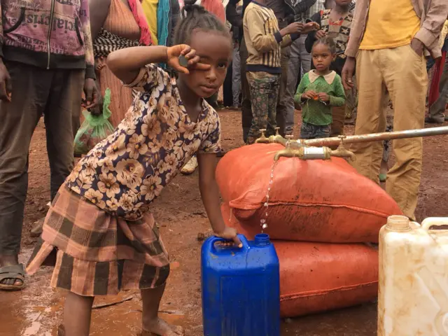 Young girl filling up a jerry can