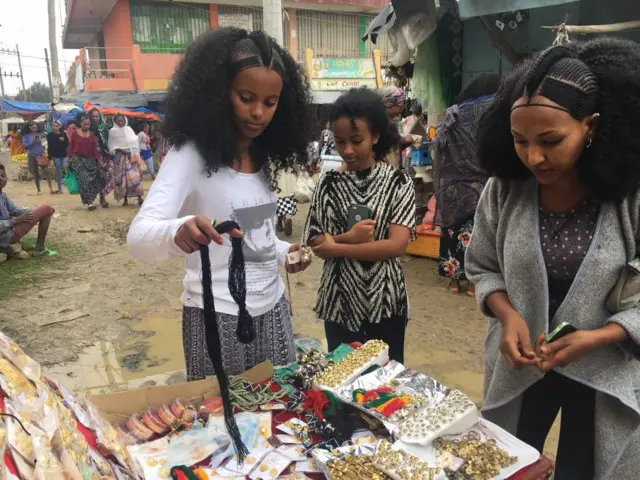 Girls pick necklaces from the market