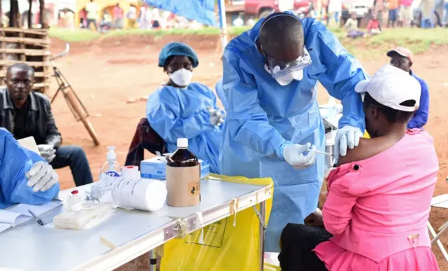 A Congolese health worker administers Ebola vaccine to a woman who had contact with an Ebola sufferer in the village of Mangina in North Kivu province of the Democratic Republic of Congo, August 18, 2018