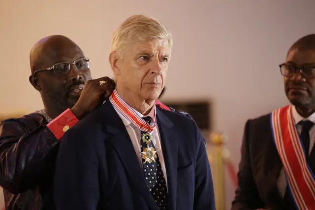 1 Liberian President, George Weah (C-R) decorates and inducts former soccer manager Arsene Wenger (C-L) into the Order of Distinction and Knight Grand Commander of the Humane Order of African Redemption at the Samuel Kanyon Doe Sports Complex, Paynesville,