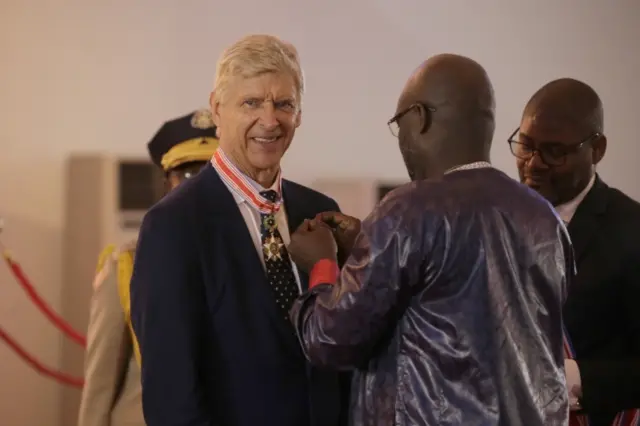 Liberian President, George Weah (C-R) decorates and inducts former soccer manager Arsene Wenger (C-L) into the Order of Distinction and Knight Grand Commander of the Humane Order of African Redemption at the Samuel Kanyon Doe Sports Complex, Paynesville, outside Monrovia, Liberia, 24 August 2018.