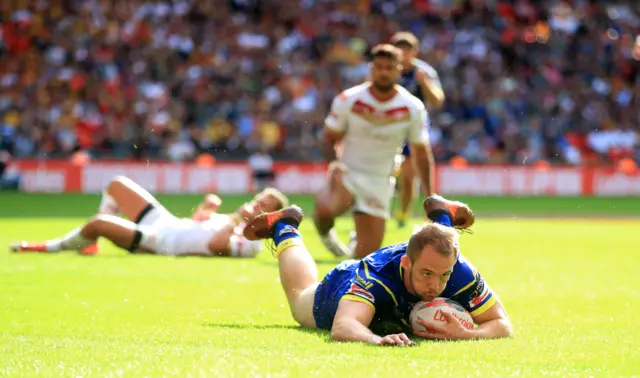 Warrington Wolves' George King dives in to score a try