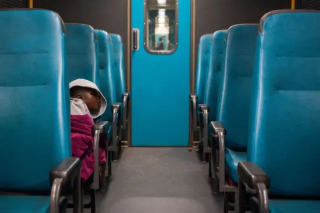 A child sleeps in a train