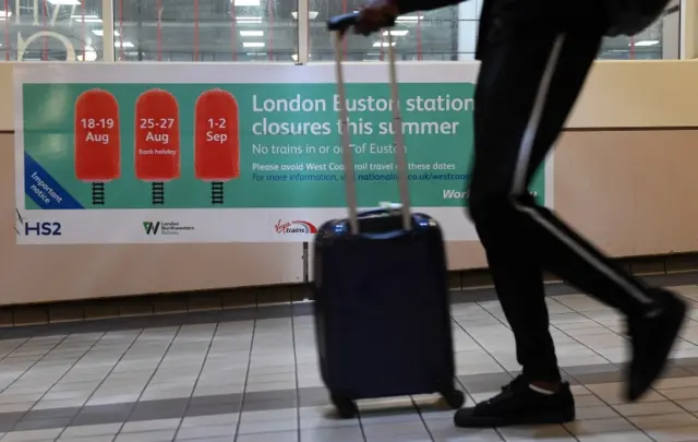 A commuter passes a closure notice at Euston Station