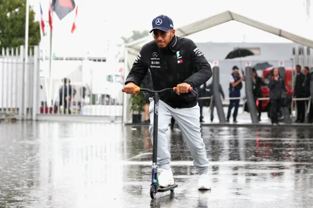 Lewis Hamilton rides a scooter in the Monza rain