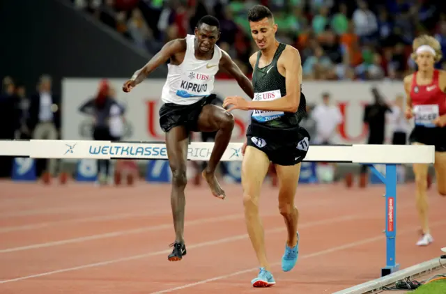 Athletes leaping over a hurdle