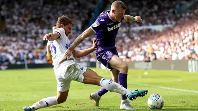 Stoke player being tackled by Leeds player