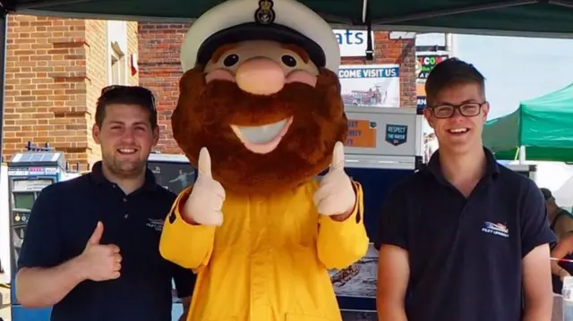 Two volunteers with a mascot