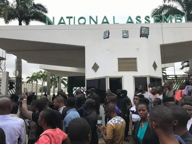 People wait outside the National Assembly