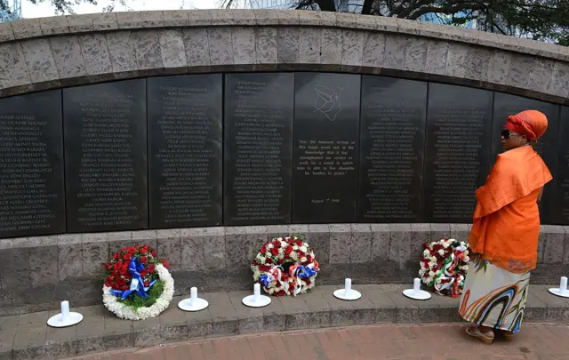 A woman stands at the memorial in Nairobi