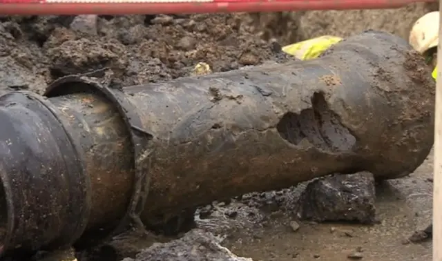 A damaged pipe with a hole in it.