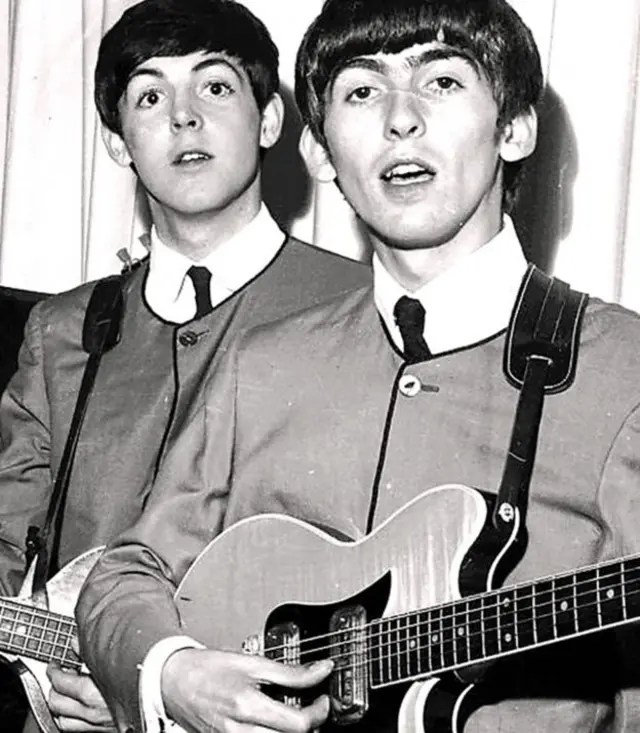 Sir Paul McCartney and George Harrison (r)