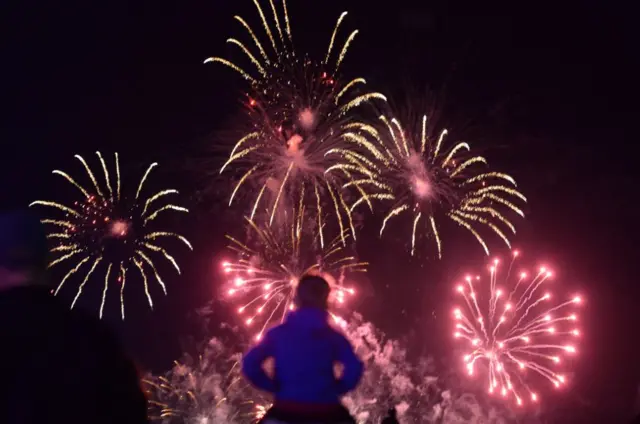 Child watched fireworks from shoulders