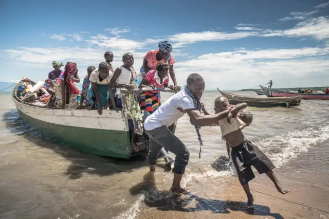 Congolese refugees exit a boat after landing in Sebagoro in the Ugandan side of Lake Albert.