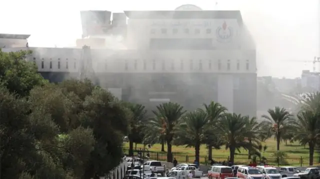 Smoke rises from the headquarters of Libyan state oil firm National Oil Corporation