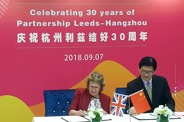 Councillor Judith Blake signs a document in China