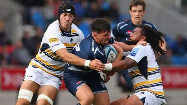 Cameron Neild of Sale Sharks is tackled by Joe Taufete"e and Andrew Kitchener of Worcester Warriors