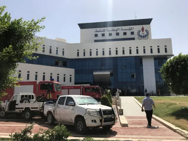 Firefighters and onlookers gather in front of the headquarters of Libya"s National Oil Company in the capital Tripoli on September 10, 2018.