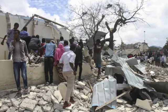 People gather at the scene of a suicde car bomb explosion in Mogadishu, Somalia, 10 September 2018