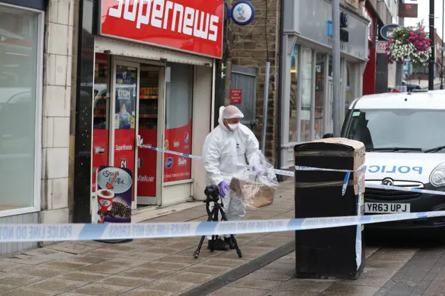 A police officer looks into a bin