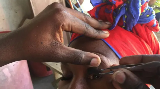 A woman having false eyelashes attached