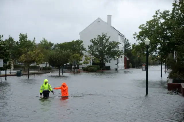 People walking in thigh-high level waters